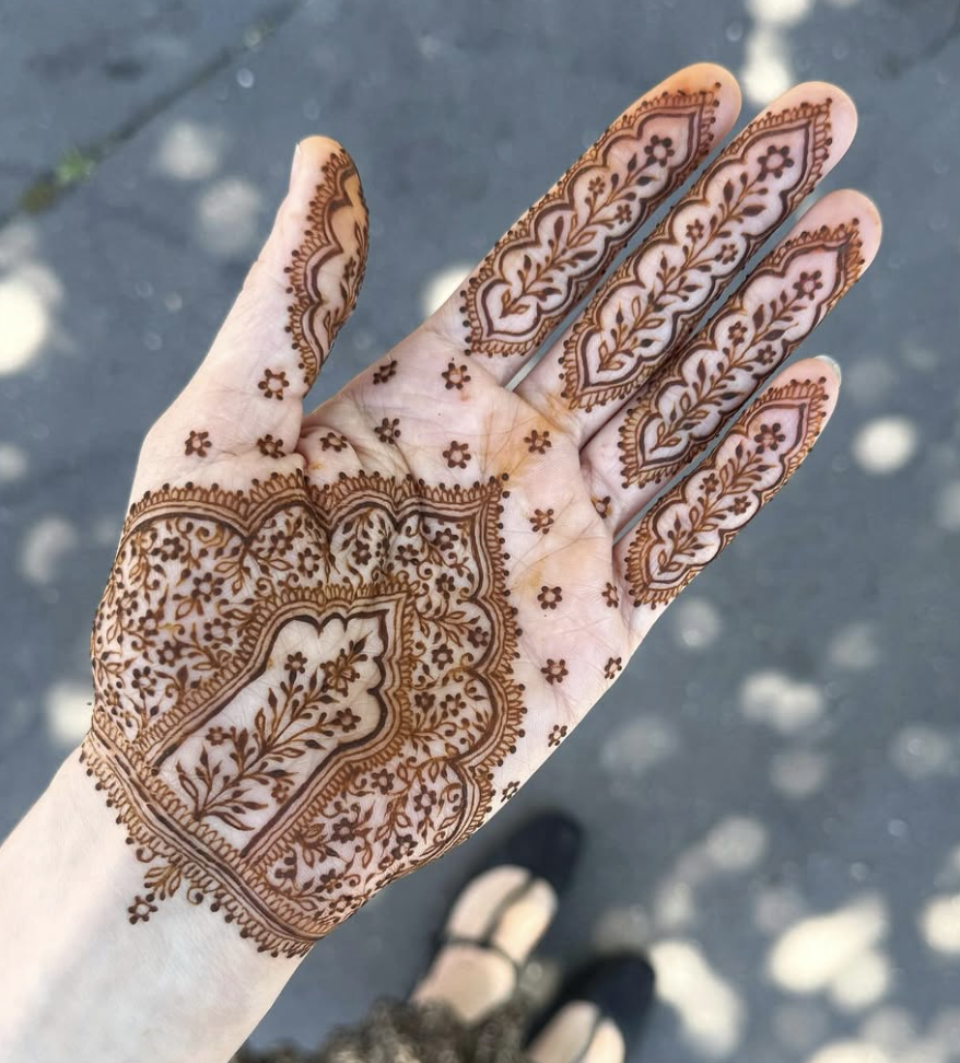 Front hand mehndi design with detailed arch-shaped floral pattern