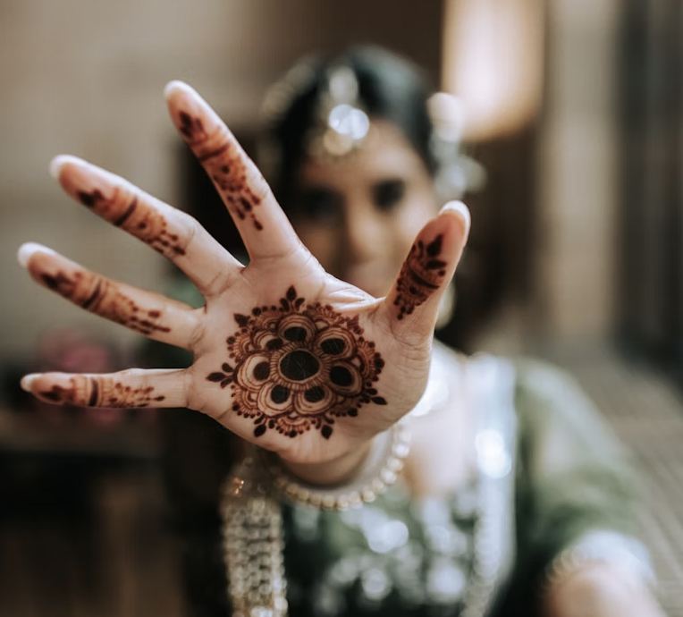 Bride showing an open palm with a simple circular front hand mehndi design