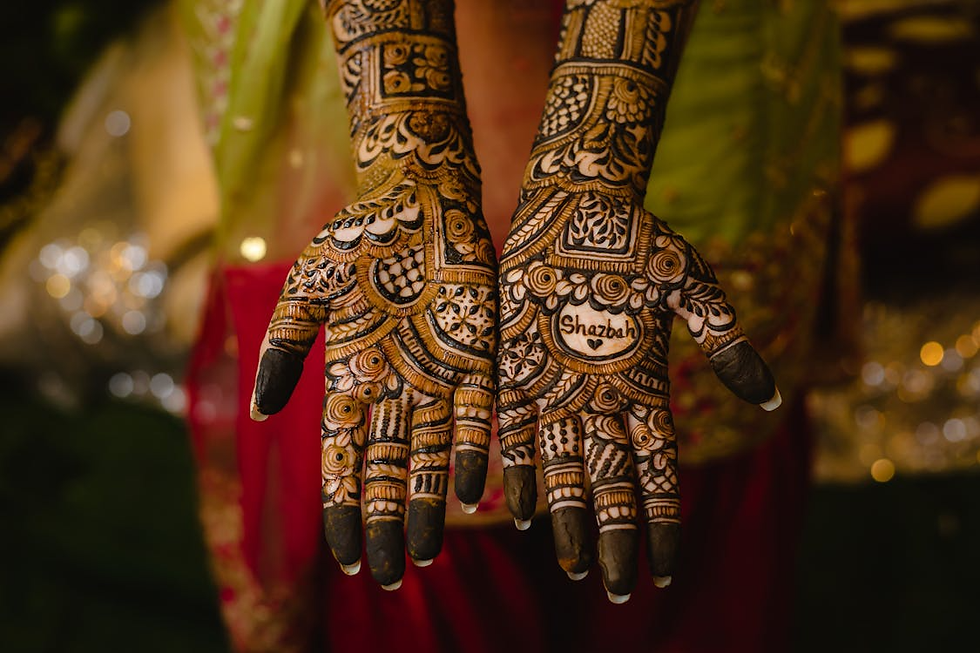 mehndi design with bold name highlight, geometric borders, and dark fingertips