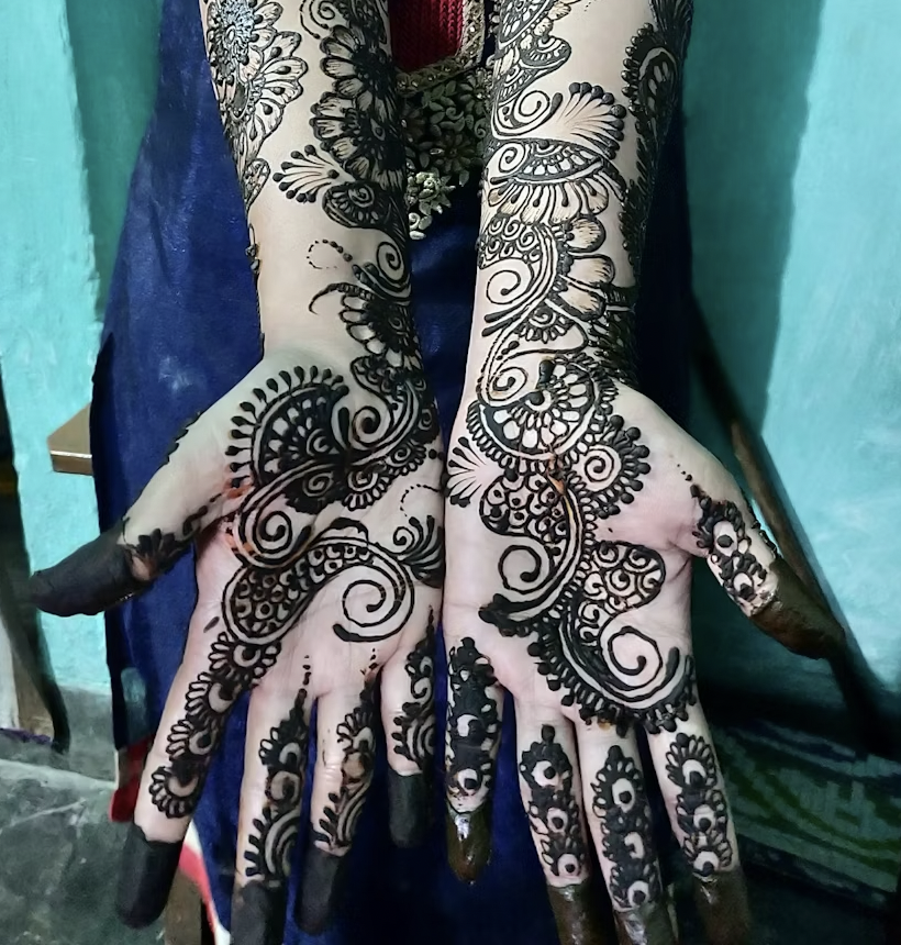 a bold and flowing front hand mehandi design with spirals, paisleys, and leafy trails