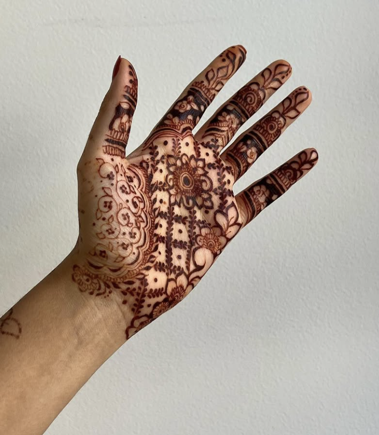Palm mehndi design with a central mandala, intricate floral patterns, and full finger detailing