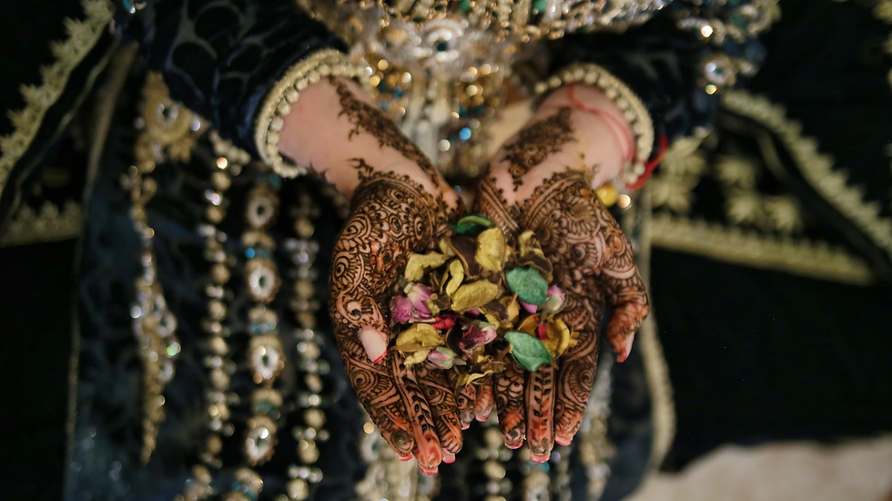 Bride cupping dried flower petals in both hands, showing full-coverage front hand mehndi designs