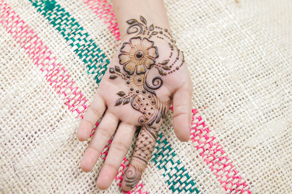 Front hand mehandi with a large flower, spiral vines, leaf accents, and a filled fingertip cone