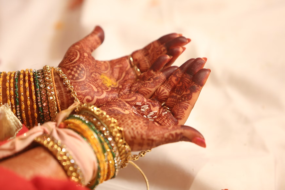 Bride’s hands cupped together holding rice during a wedding ritual, decorated in full-coverage front hand mehndi