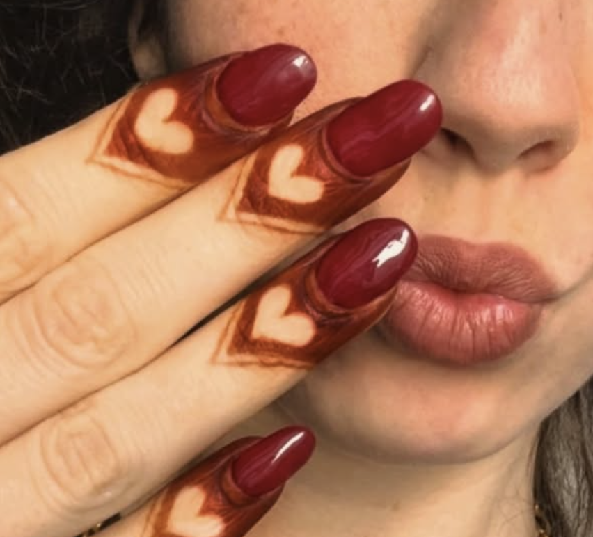 mehndi design on fingertips with heart-shaped negative space and bold outline