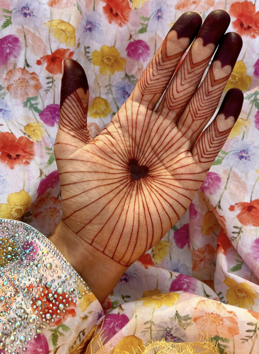 Palm mehndi design with central heart motif and fine radiating lines