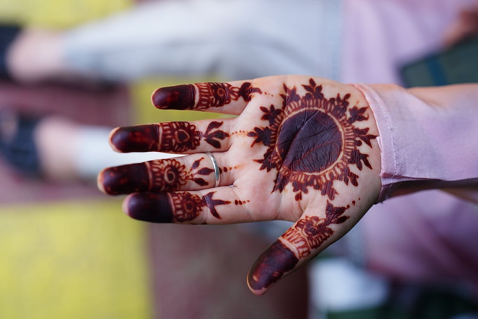 Front hand mehandi design with a real leaf impression in the palm, surrounded by bold henna petals and dyed fingertips