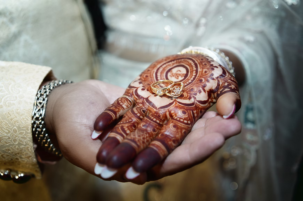bride’s palm with detailed front hand mehndi design and gold engagement ring