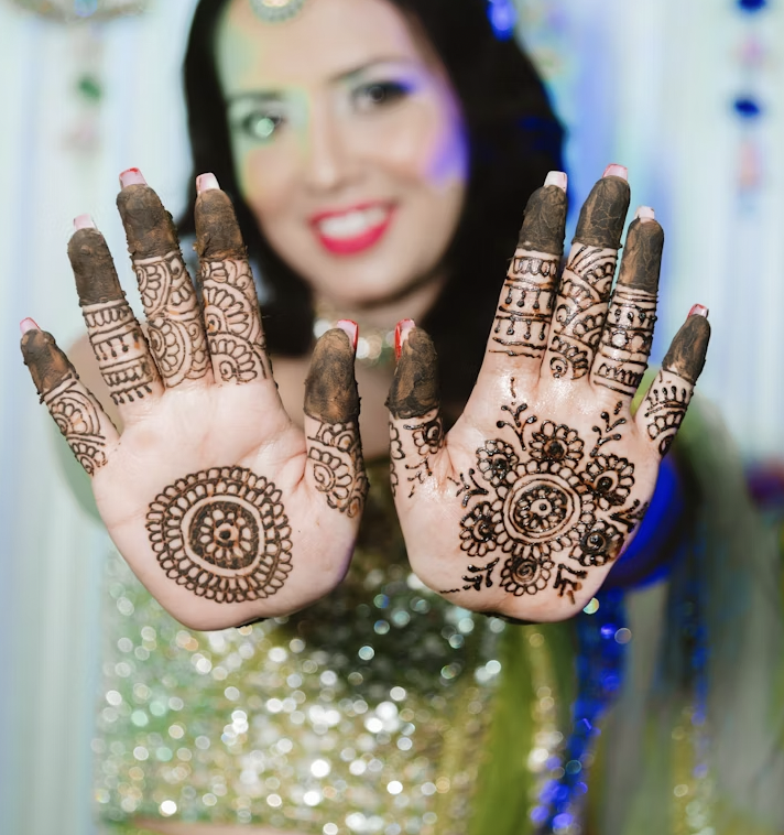 showing front hand mehndi designs featuring floral mandalas and dark fingertips