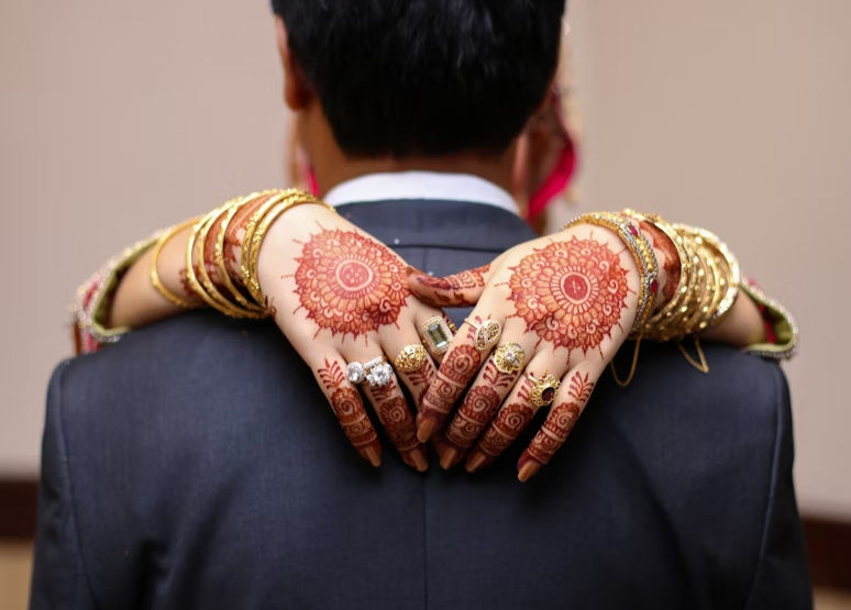 Bride's back hand mehndi design with symmetrical mandala patterns on each hand