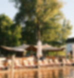 Liegestühle und Sonnenschirme im Beachclub am Oyter See