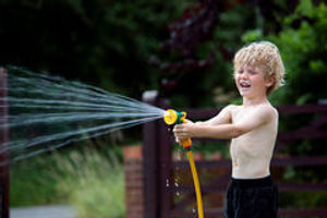 young-boy-playing-hosepipe-garden-121232