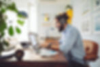 Man sits at desk and working on his laptop