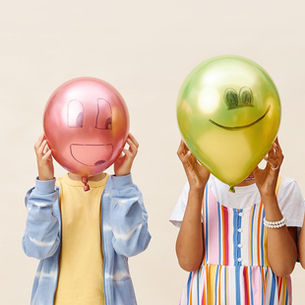 Four teens hiding behind ballons
