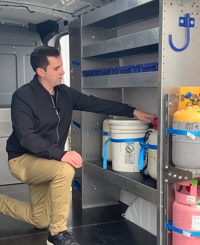 man inside a van looking at shelving system