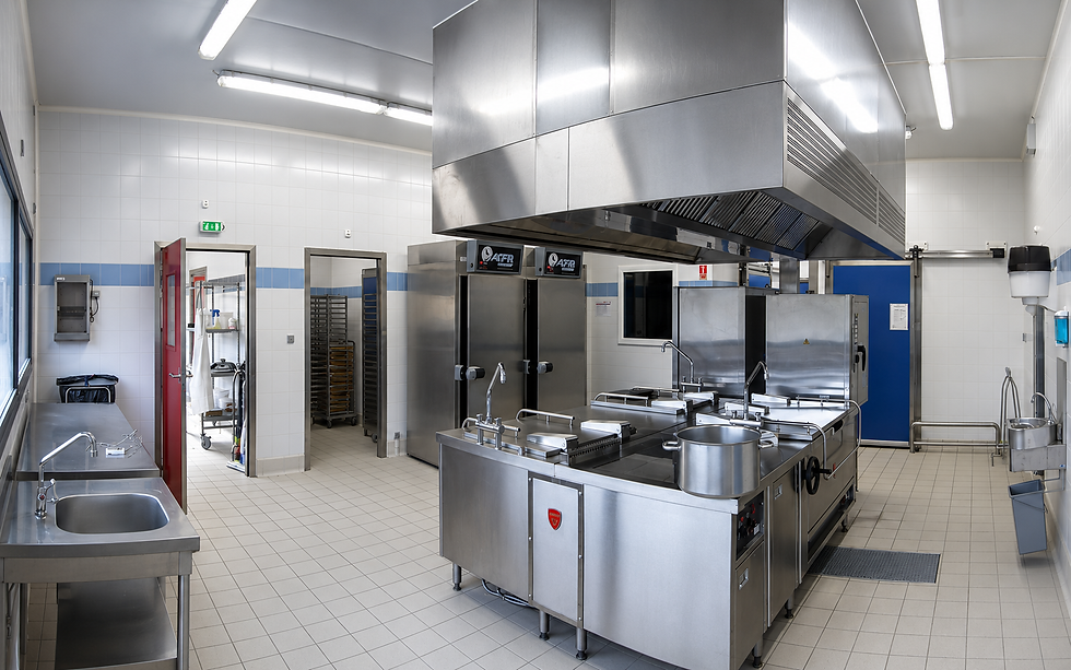 Cuisine professionnelle avec plaques de cuisson et crédence carrelée, ambiance lumineuse et moderne.