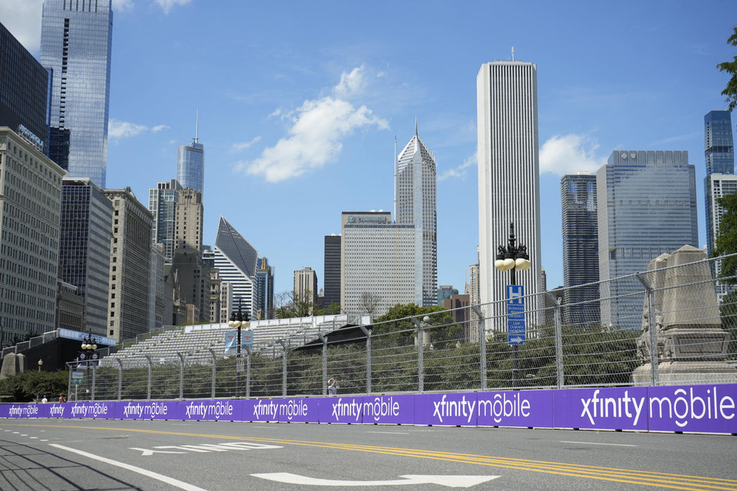 Custom-printed Xfinity sponsorship banners lining the NASCAR Chicago race track, event signage designed for brand visibility.