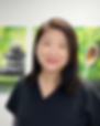 image of female acupuncturist in black scrubs standing in a front of a green and white backdrop of balancing stones. female is asian with mid length brown hair
