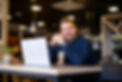portrait-smiling-man-sitting-cafe-bar-with-his-laptop-computer.jpg