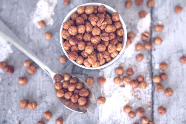 Bowl of seasoned roasted chickpeas with a spoon