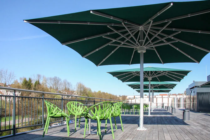 Blick unter dunkelgrüne Großschirme auf einer Terrasse mit Holzdeck: Mast, Nabe und Streben aus Aluminium