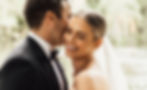 A bride laughing as her new husband kisses her ear