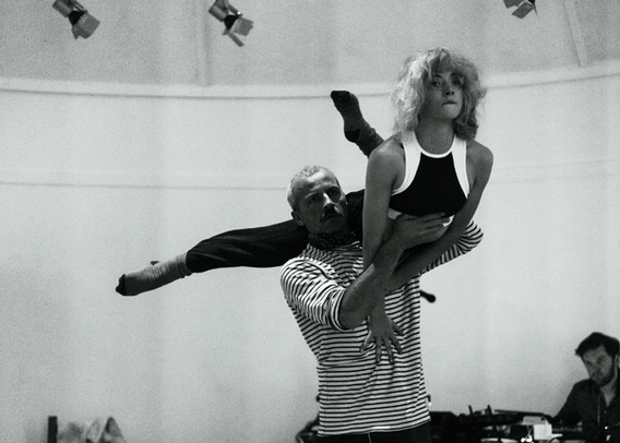Man holding woman on his shoulder by her core doing duo acrobatics