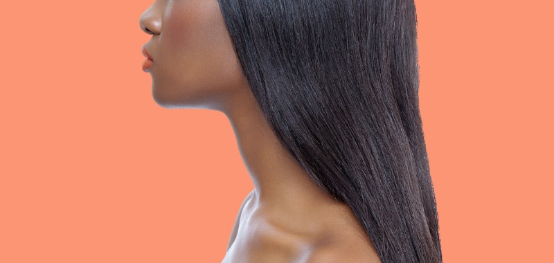 Woman with sleek long dark straight hair on an orange background