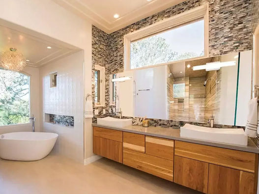 Modern bathroom remodel with wood vanity, double sinks, large mirrors, soaking tub, and tiled shower.