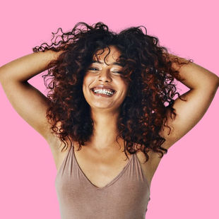 woman with curly hair on a pink background