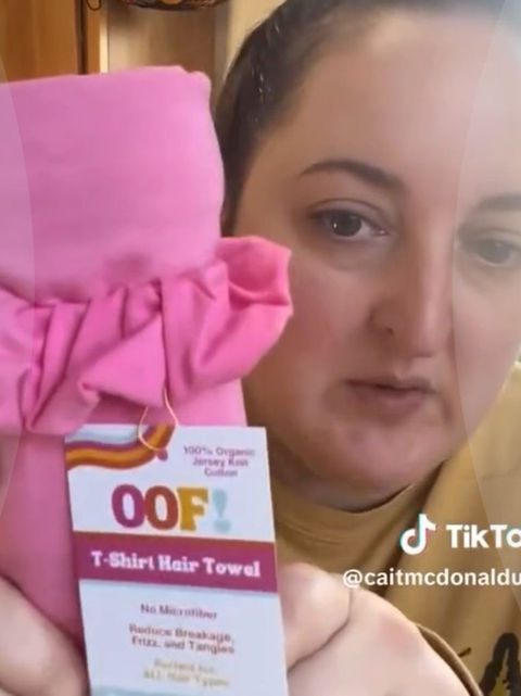 HALO fan from TikTok holding up a pink HALO t-shirt hair towel
