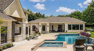 Detached guest house in a backyard with matching architecture, finished exterior, and planned connection to the main home.