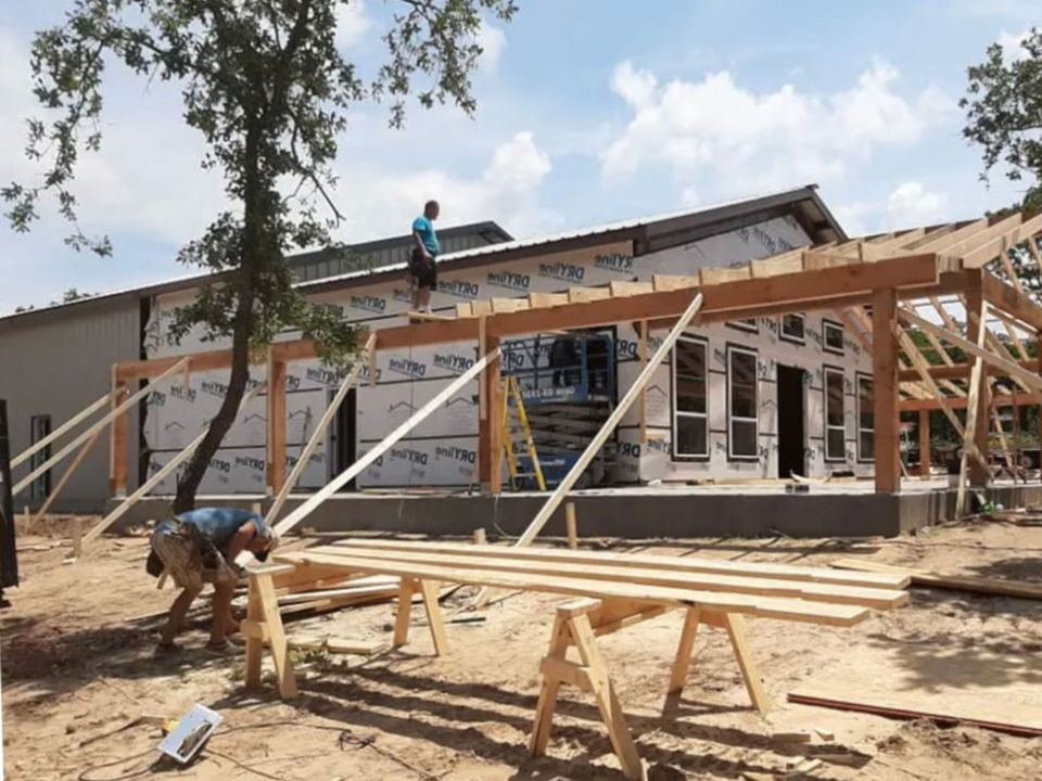 New home construction in North Texas with workers framing a custom covered porch