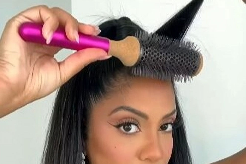 woman with a round brush styling curtain bangs