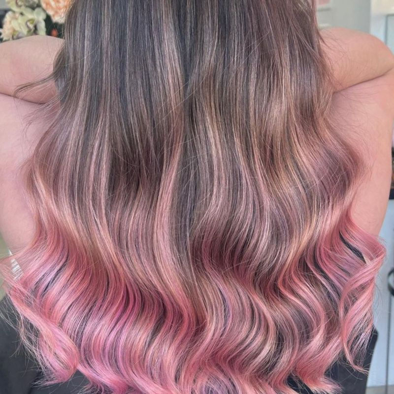 Woman with brunette highlighted hair wuth pink pastel pops of color