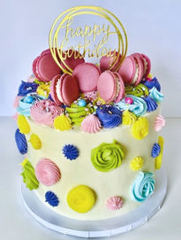 Colorful custom cake with macarons and 'Happy Birthday' topper