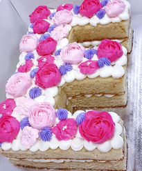 Custom E shaped cake with pink & purple flowers