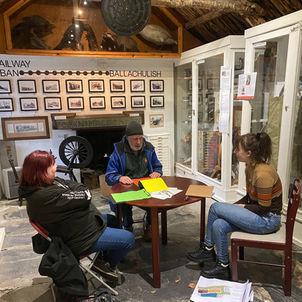 Inside Glencoe Folk Museum, people sat around table with papers