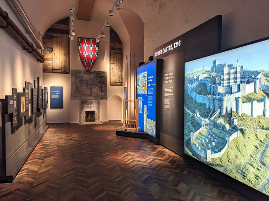 Casemate building with graphic panels featuring text and images include illustration of the castle. A shield suspended at the far end.