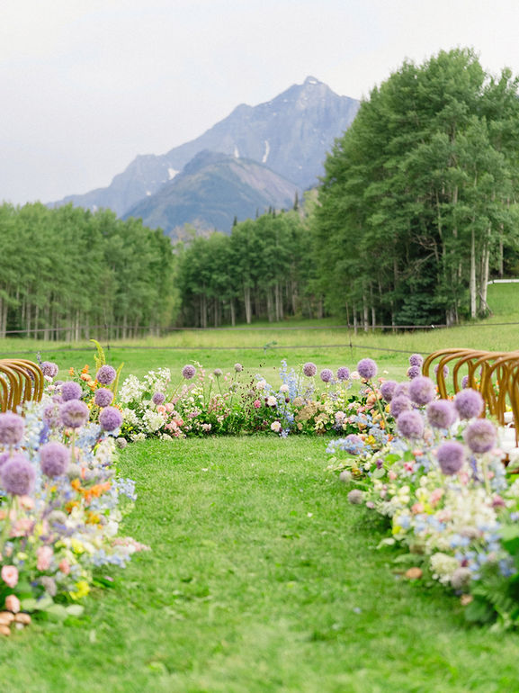 Whimsical, pastel ceremony flowers for meadow wedding in Aspen