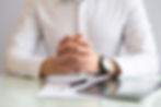 close-up-male-executive-sitting-table-with-clasped-hands.jpg