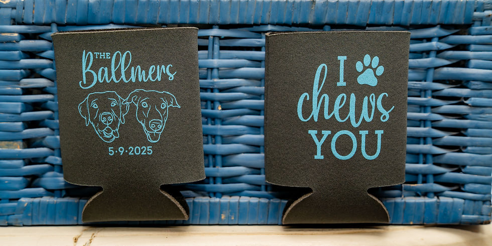 Two black drink koozie wedding favors with blue text and dog graphics; one reads "The Ballners 5-9-2025," the other "I chews you," on a blue wicker backdrop at a wedding venue near Sugar Land Texas