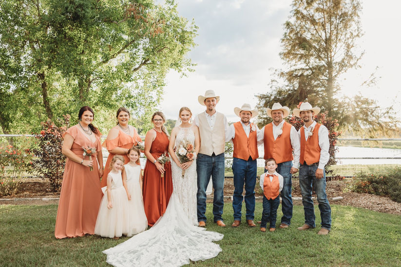 Bride, groom and their wedding party pose in a rose garden surrounded by trees, roses and our pond at a ranch venue near Sugar Land, Texas.