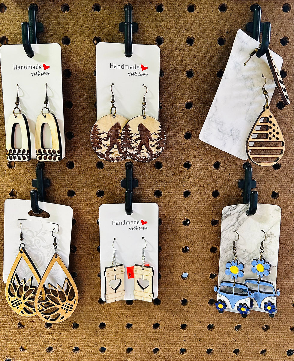 Elaine and John Noble's booth features a collection of handmade earrings, including retro-style vans and fun Bigfoot designs, perfect for those seeking a groovy vibe or a cottage-core accent to any outfit!