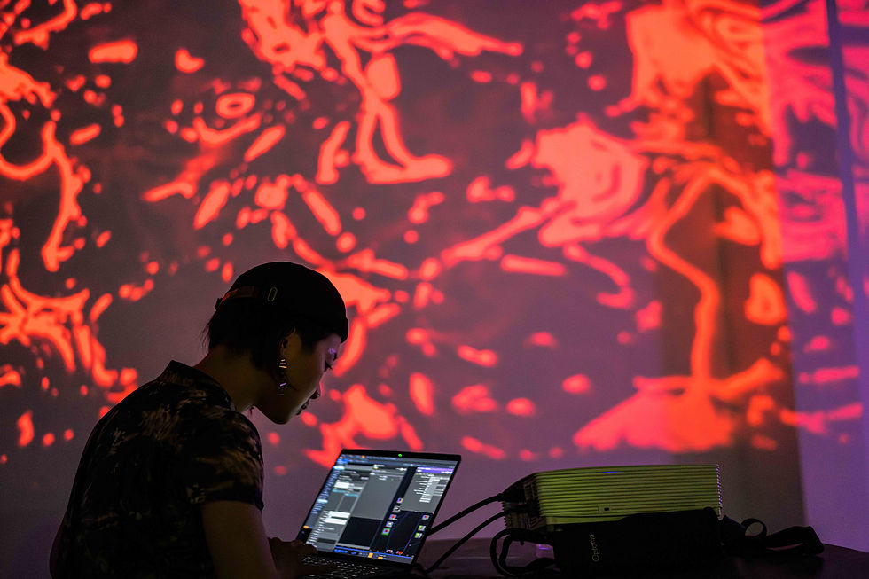 Zelia performing a VJ set (2024) at a club event alongside her dance cohort and professor Ariel Osterweis, blending real-time visuals and movement in a vibrant, high-energy environment / Photo provided by Zelia ZZ Tan
