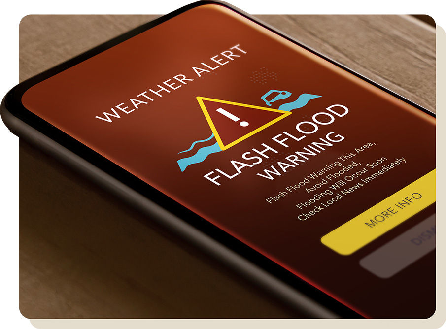A smartphone with a flash flood warning message on it.