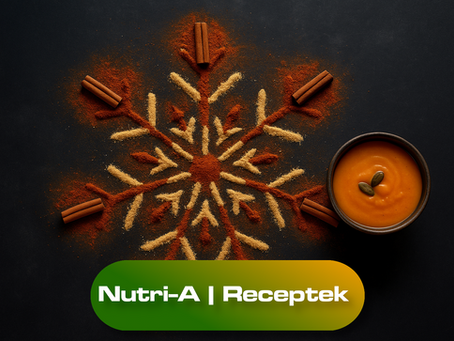 Fűszerekből kirakott hópehely mandala sötét háttéren, fahéjrudas díszítéssel és egy tál sütőtökkrémlevessel a kép szélén.