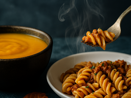 Gluténmentes őszi comfort food: gőzölgő sütőtökkrémleves és paradicsomos fusilli tészta művészi közeliben.