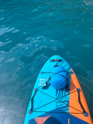 Paddleboard floating in blue water with text Enjoy the Ocean, Sup Club Positano