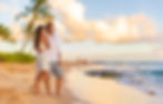 Couple on romantic sunset beach walk relaxing during Hawaii summer travel vacation on Kaua